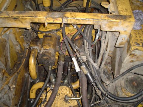 1966 International School Bus - Engine compartment of heavy machinery, showing hydraulic hoses and wiring.