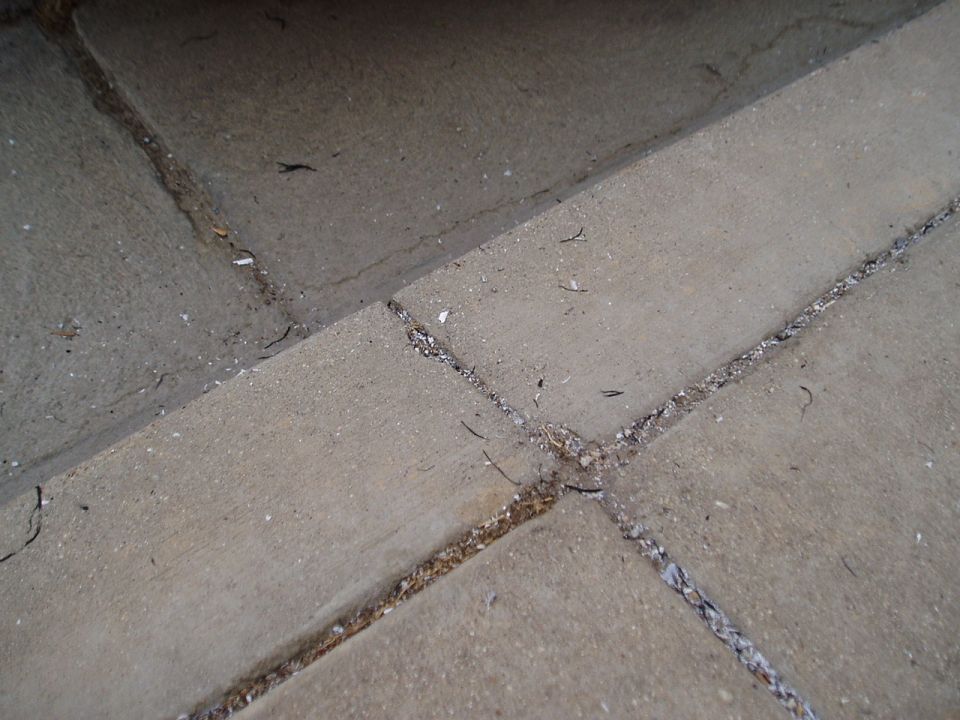 Concrete pavement with visible cracks and debris