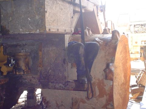 1966 International School Bus - A person is working on the interior of a large, industrial machine, possibly undergoing repairs.