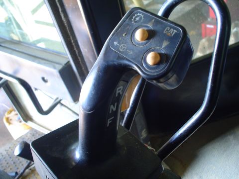 1966 International School Bus - The interior of a piece of CAT equipment shows the gear selector and control panel with buttons.