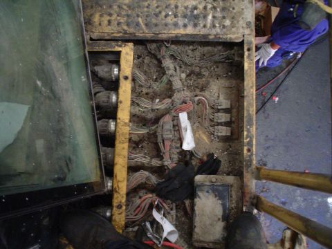 1966 International School Bus - A view of the complex and dirty wiring harness and electrical components within a vehicle's compartment.