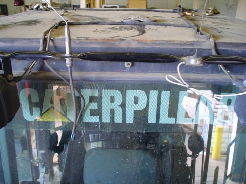1966 International School Bus - Interior of Caterpillar equipment cab, showing the windshield with brand logo and dashboard details.