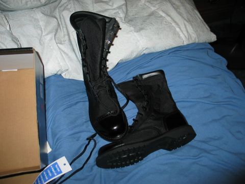 1995 Ford Bronco - A pair of black combat boots with laces and shiny toe caps are laid out on a blue surface.