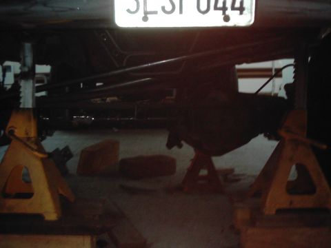 1978 Ford Bronco - Vehicle's rear axle and suspension components are visible while it's raised on jack stands.