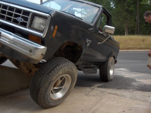 1985 Ford Bronco II - A black 1985 Ford Bronco II is shown at an angle with its front driver's side wheel elevated.