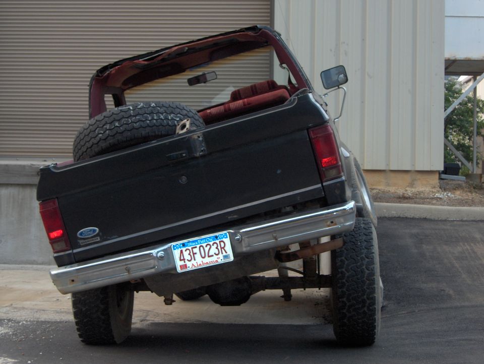 Rear view of black 1985 Ford Bronco II convertible with spare tire