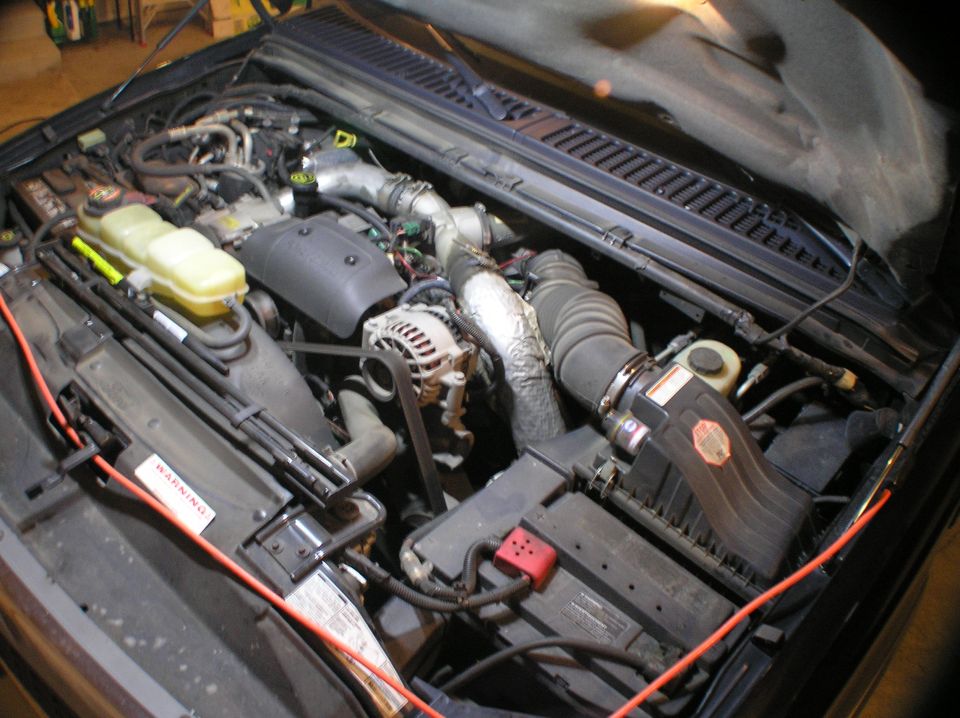 Overview of engine compartment before the alternator install (the orange cord is an extension cord ran to the lights I have hanging under the hood of the Excursion).