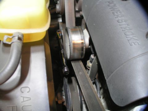 2000 Ford Excursion - A close-up view of a vehicle's engine belt tensioner being adjusted with a socket wrench.