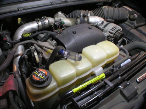 2000 Ford Excursion - Keeping tension on the belt by propping it up with a screwdriver while the alternator gets removed.