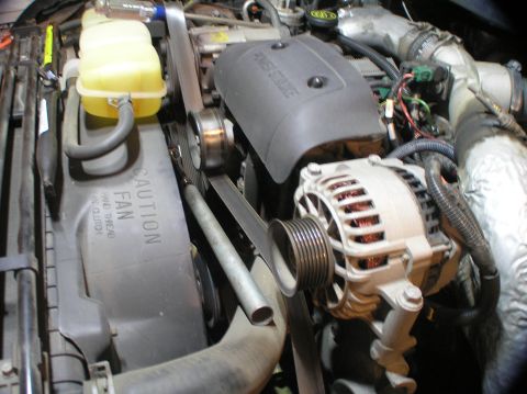 2000 Ford Excursion - Close-up view of an engine compartment, focusing on the alternator and related components.