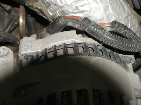 2000 Ford Excursion - Vehicle alternator with wiring harness and insulation visible.