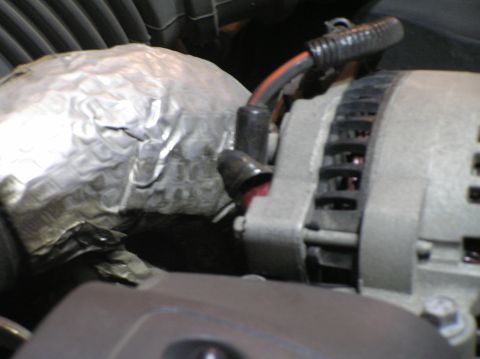 2000 Ford Excursion - The alternator and a section of insulated piping are visible in this engine bay close-up.