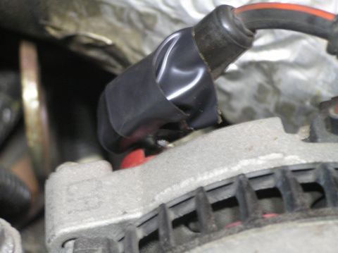2000 Ford Excursion - Electrical tape covers a wire connection on an automotive alternator.