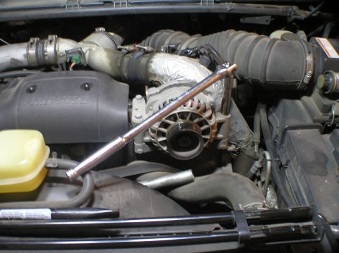 2000 Ford Excursion - Alternator replacement in progress on a Power Stroke diesel engine, tool is attached.