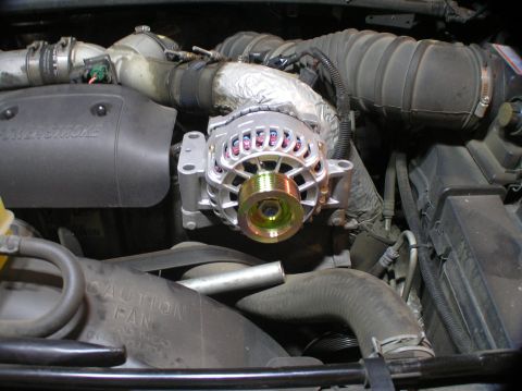 2000 Ford Excursion - Close-up of a newly installed alternator within the engine compartment of a 2000 Ford Excursion.