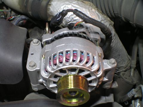 2000 Ford Excursion - A close-up view of a vehicle's alternator, a key component in the charging system.
