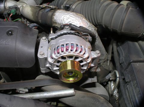2000 Ford Excursion - Close-up view of a vehicle's alternator and surrounding engine components.