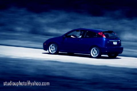 2002 Ford Focus - Blue 2002 Ford Focus hatchback on a track, captured in motion.