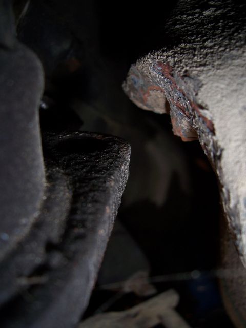 1983 Ford Bronco - This image shows heavily rusted metal parts, likely from the underside of a vehicle, with a watermark for SuperMotors.net.