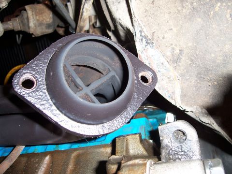 1983 Ford Bronco - Close-up of an exhaust manifold flange and gasket, showing connection to an engine block.
