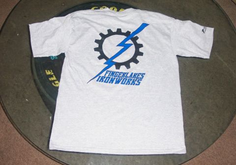 1979 Ford F-150 - A t-shirt with a gear and lightning bolt logo is displayed on a table.