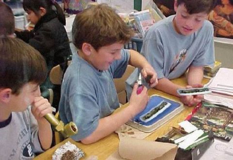 1986 Ford Bronco - Children are engaged in a hands-on activity, possibly a school project, at a table with various materials.
