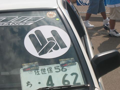 1986 Ford Bronco - Close-up of a car's windshield, showing various stickers and a license plate.