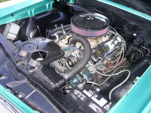 1967 Pontiac Lemans - The engine bay of a 1967 Pontiac Lemans features a V8 engine with chrome valve covers displaying 'GTO' badging and a prominent air cleaner.