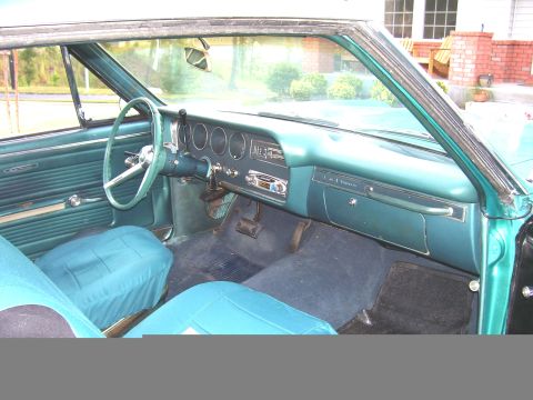 1967 Pontiac Lemans - Interior view of a classic car, teal upholstery and a dashboard with multiple gauges.