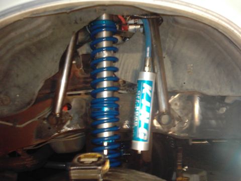 1978 Ford Bronco - Close-up of a King Off-Road shock absorber with a blue coilover spring, likely part of an upgraded suspension system.
