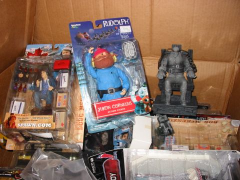 1991 Ford Bronco - A collection of toys, including action figures and a figure in an electric chair, are packed inside a cardboard box.