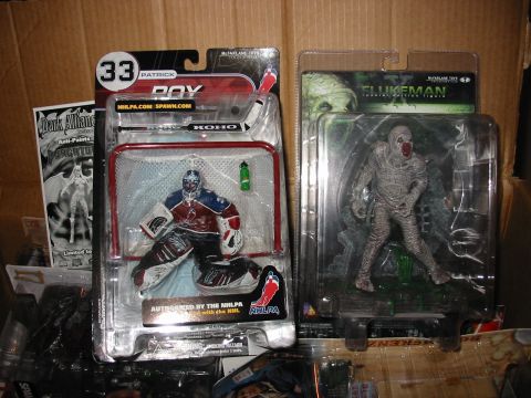 1991 Ford Bronco - A collection of packaged action figures, including a hockey player and a mummy, are displayed in a cardboard box.