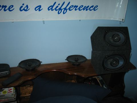 1995 Ford Bronco - Car speakers are displayed on a wooden shelf against a blue wall with a banner above.