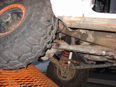 1995 Ford Bronco - Close-up view of the front suspension and oversized tire of a 1995 Ford Bronco.