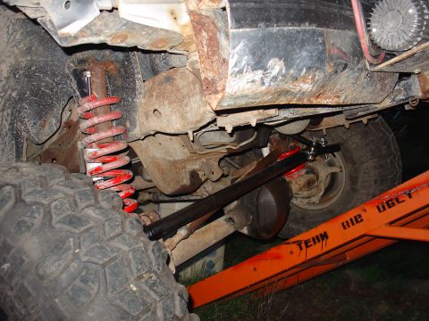 1995 Ford Bronco - The underside of a heavily rusted vehicle is shown, with visible suspension components and large tires.