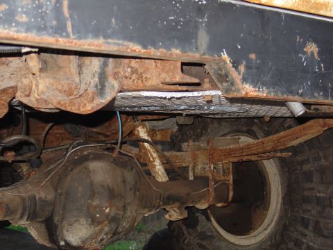 1995 Ford Bronco - The underside of the vehicle shows significant rust and wear on its suspension components.
