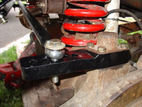 1995 Ford Bronco - Vehicle suspension component with a ball joint and red coil spring visible.