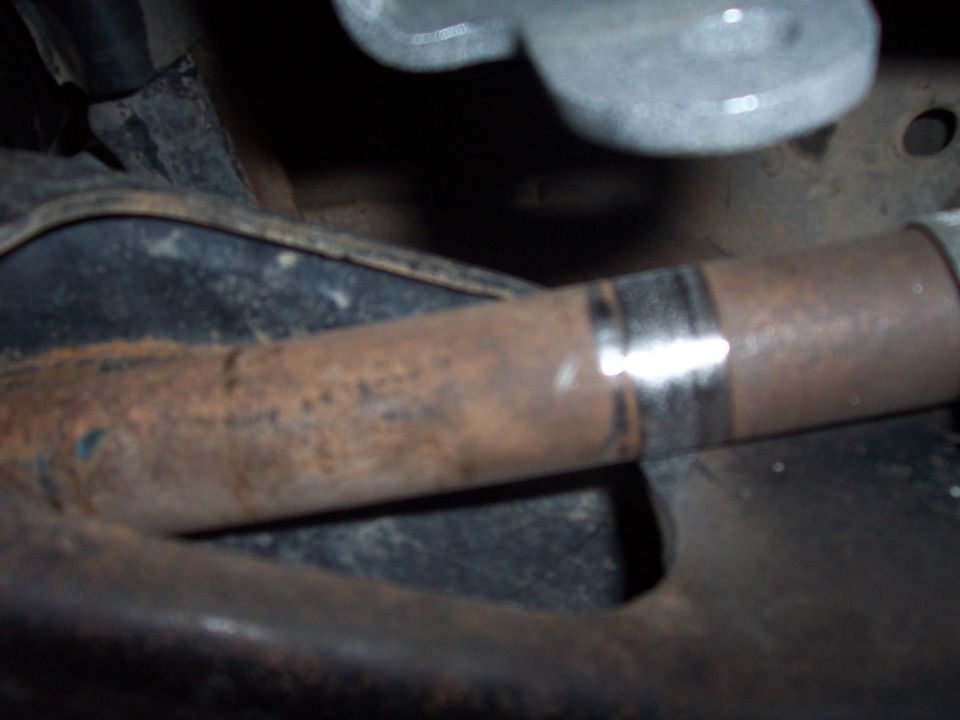 Rusty exhaust pipe with a clamp, viewed from below