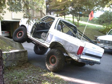 1995 Ford Bronco - This modified Ford Bronco is shown with its doors removed and a roll cage installed, suggesting off-road use.