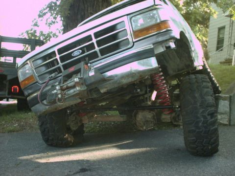 1995 Ford Bronco - This lifted Ford truck features a winch mounted to the front bumper and bright red coil springs.