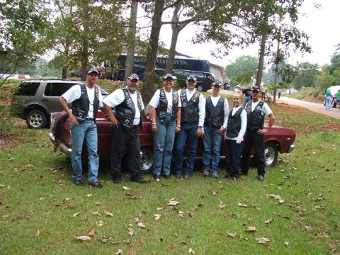1966 Ford Ranchero - A group of people pose with a red 1966 Ford Ranchero, with another SUV visible in the background.