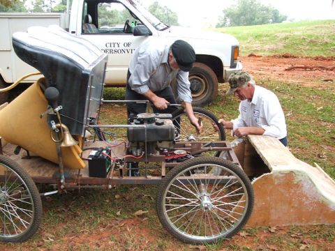 1966 Ford Ranchero - Two men are working on a custom-built vehicle, possibly a go-kart or replica, with a white pickup truck in the background.