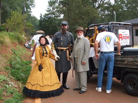 1966 Ford Ranchero - A group poses in historical attire next to a utility vehicle during an outdoor event.