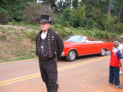 1966 Ford Ranchero - A man in historical attire poses beside a bright red convertible on a tree-lined road.