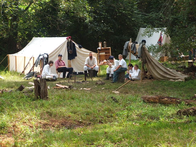 Civil War reenactment camp with tents and people in period clothing