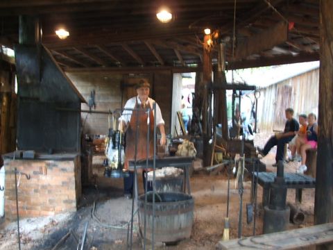 1966 Ford Ranchero - A blacksmith works in a shop while visitors observe the process.