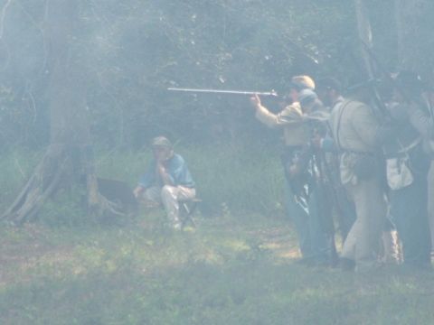 1966 Ford Ranchero - A historical reenactment scene unfolds with participants dressed in period attire, some holding muskets.