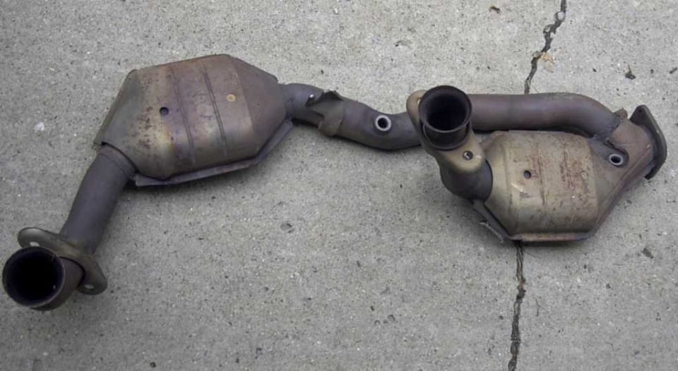 Dual catalytic converter Y-pipe exhaust assembly lying on cracked concrete