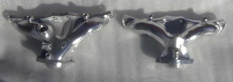 1997 Ford Taurus - Two chrome exhaust manifolds are shown side-by-side.