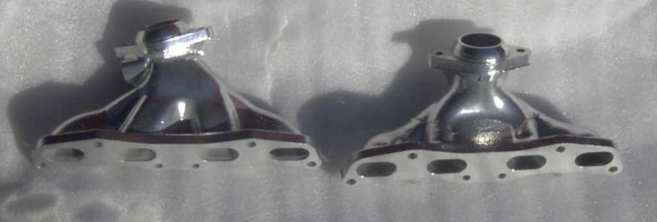 Two chrome exhaust manifolds on a white surface